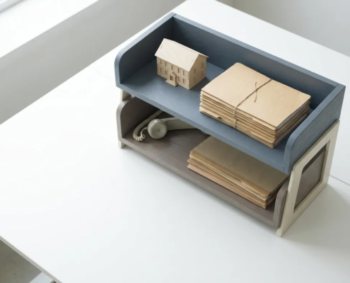 Houten bureauorganizer met twee niveaus, gevuld met geordende dossiers, een miniatuur woongebouw en een telefoonhoorn.
